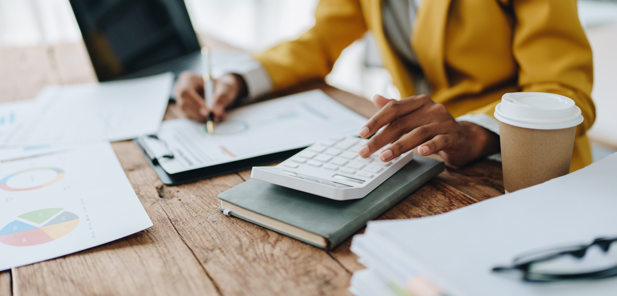 a person reviewing finances with a calculator at their desk