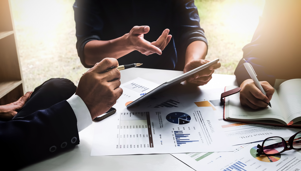 a group reviewing financial reports and taking notes during a consultation